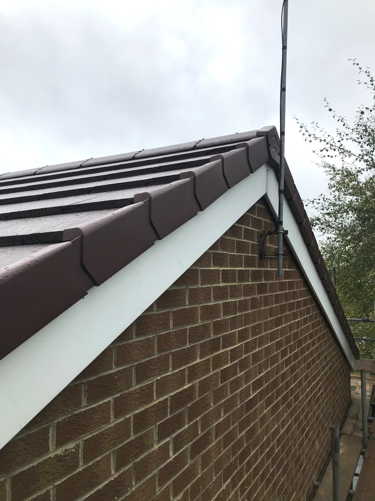 Brown dry verge tiles and white fascia on a gable roof