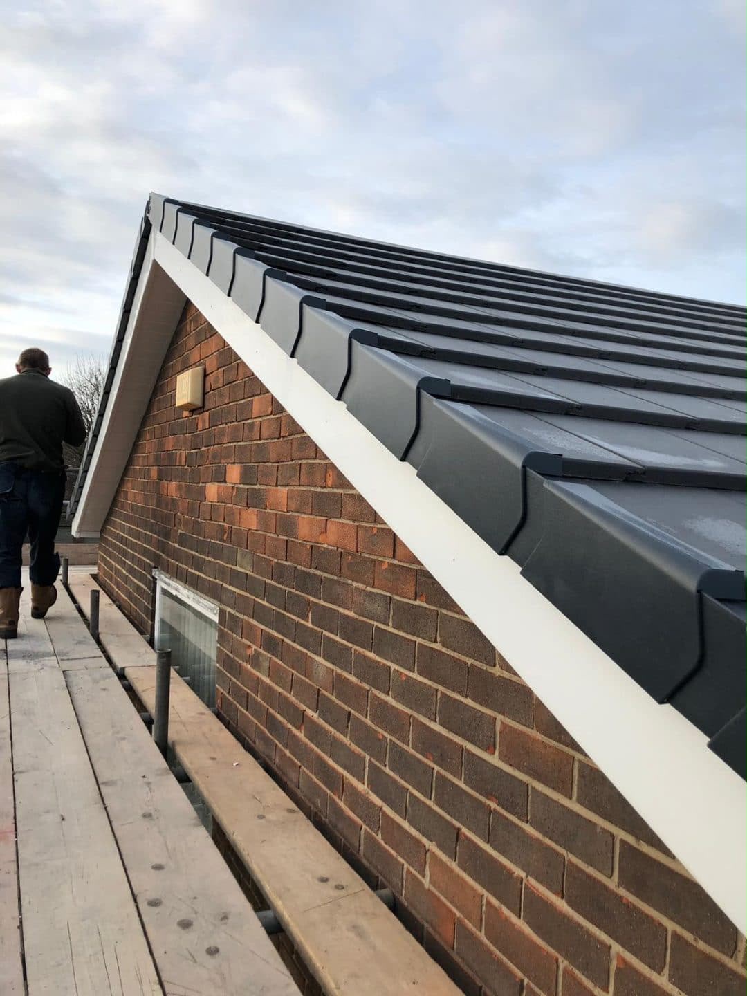 Dark dry verge system along a gable roof